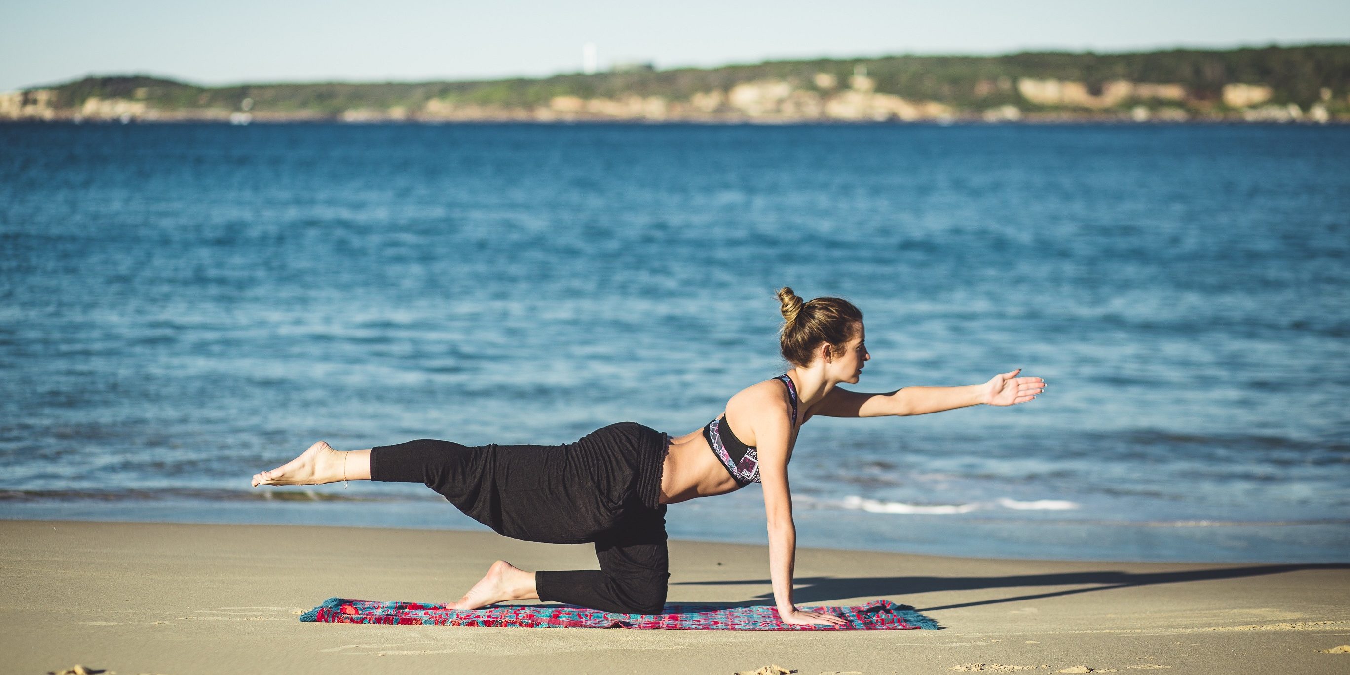 O femeie face sport pe malul marii