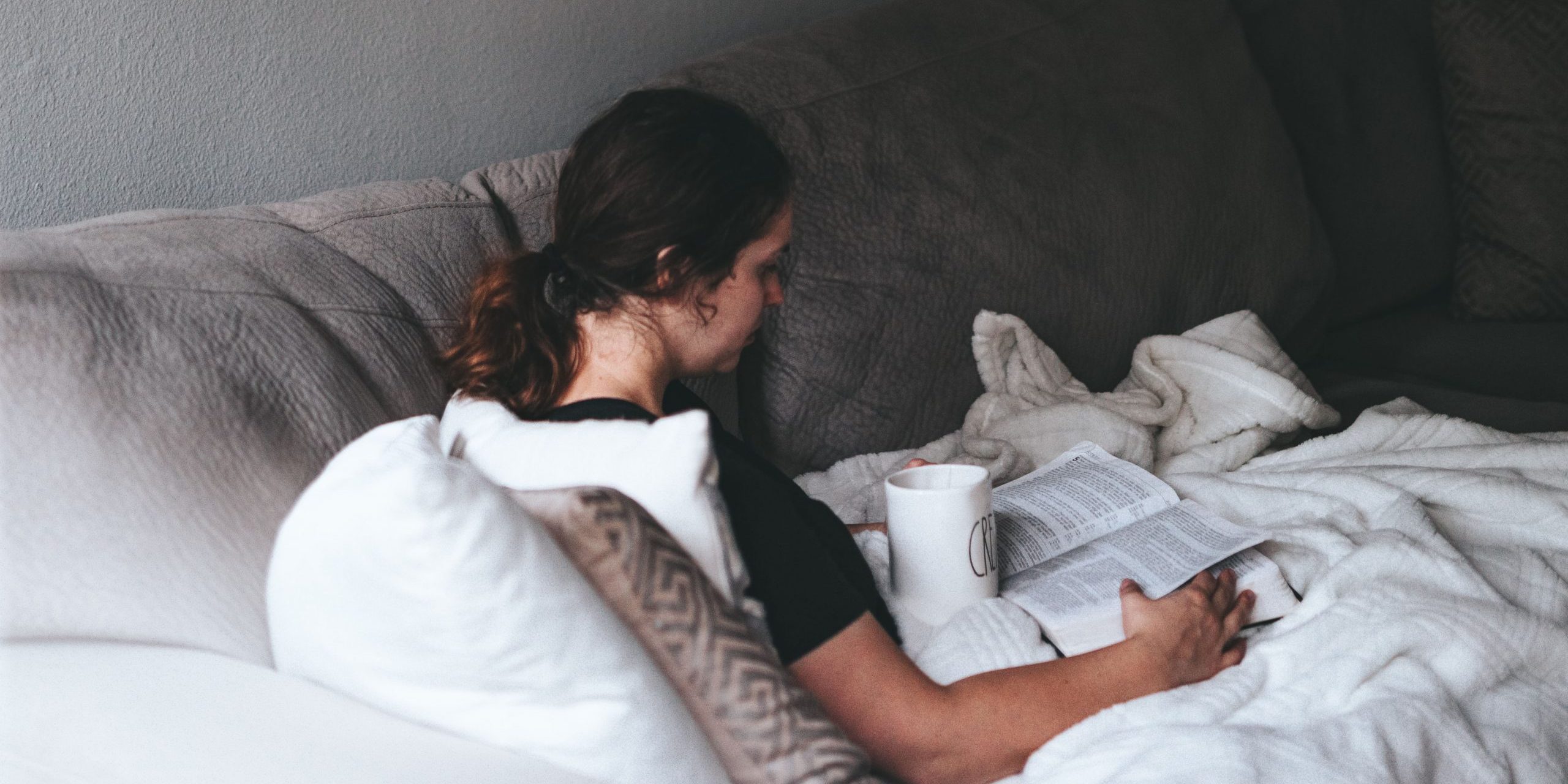 femeie carte citeste canapea